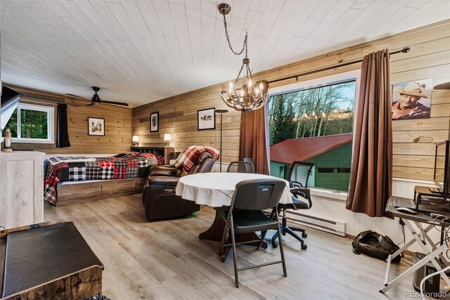 2150 Michigan Hill Rd, Jefferson, CO 80456 - dining space featuring a baseboard heating unit, wooden walls, wood finished floors, a chandelier, and ceiling fan