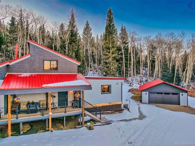 2150 Michigan Hill Rd, Jefferson, CO 80456 - view of front of property featuring covered porch, a garage, an outbuilding, and a wooded view