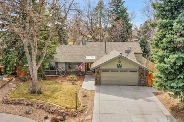 view of front of property featuring driveway, a front yard, fence, an attached garage, and brick siding