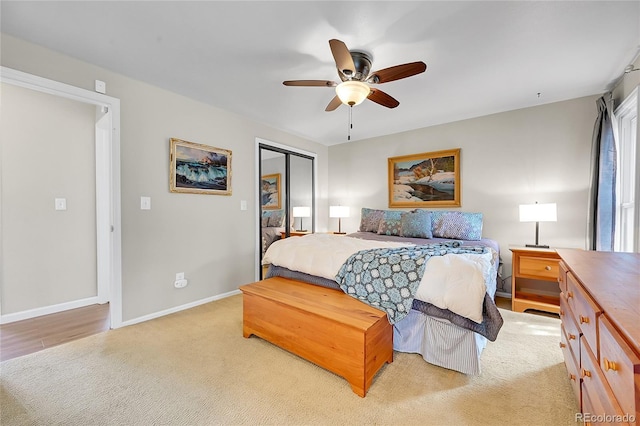 carpeted bedroom with a closet, baseboards, and ceiling fan