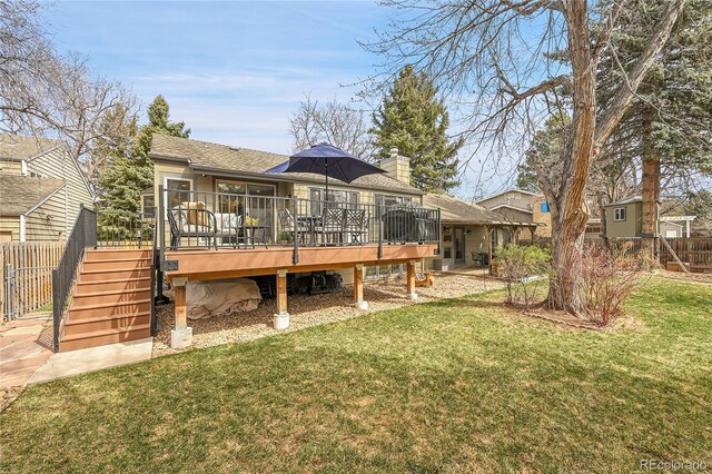 back of house with a wooden deck, fence, a lawn, and a chimney