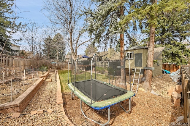 view of yard featuring a fenced backyard, an outbuilding, and a trampoline