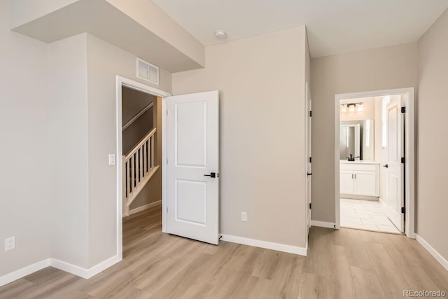 9629 Browns Peak Cir, Littleton, CO 80125 - unfurnished bedroom featuring light wood-style flooring, baseboards, and connected bathroom