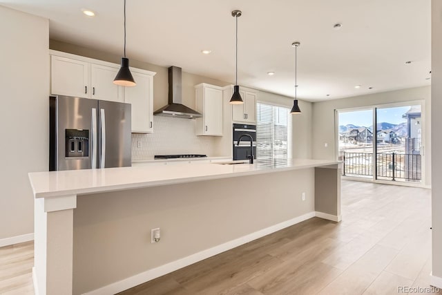 9629 Browns Peak Cir, Littleton, CO 80125 - kitchen with stainless steel fridge, wall chimney range hood, a large island with sink, a sink, and tasteful backsplash