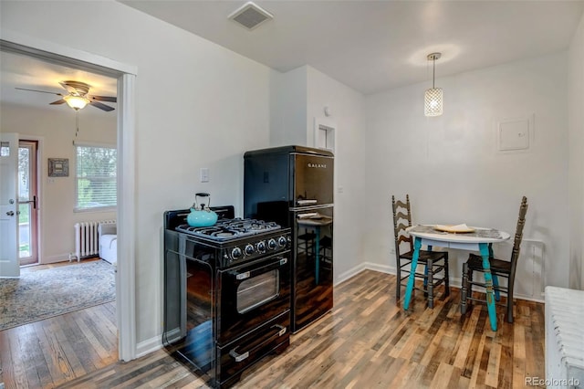 kitchen with radiator heating unit, ceiling fan, black appliances, and hardwood / wood-style floors