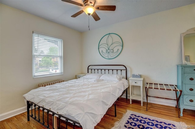 bedroom featuring radiator, ceiling fan, and wood-type flooring