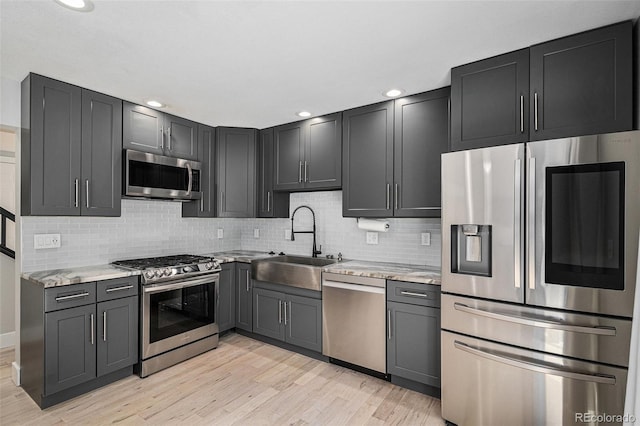 19334 E Prentice Pl, Centennial, CO 80015 - kitchen with appliances with stainless steel finishes, decorative backsplash, light wood-style floors, light stone countertops, and recessed lighting