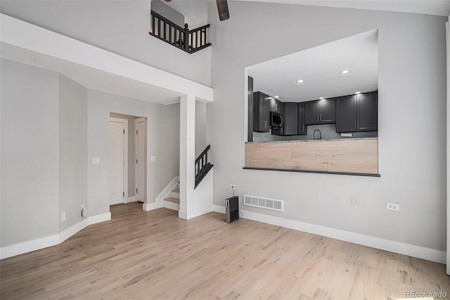 19334 E Prentice Pl, Centennial, CO 80015 - unfurnished living room featuring light wood-type flooring, stairs, a ceiling fan, and recessed lighting