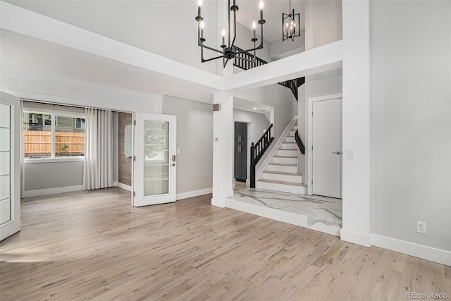 19334 E Prentice Pl, Centennial, CO 80015 - unfurnished living room with stairway, a chandelier, wood finished floors, and a high ceiling