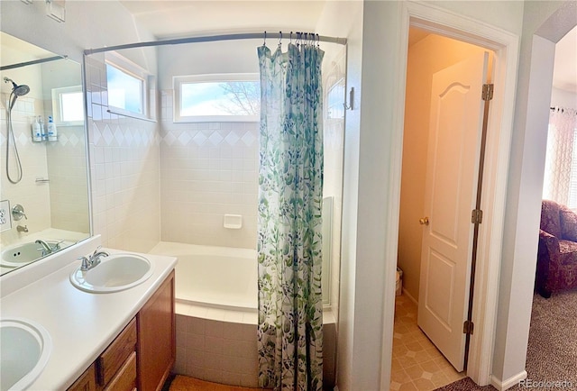 bathroom with a sink, tiled shower / bath combo, and double vanity