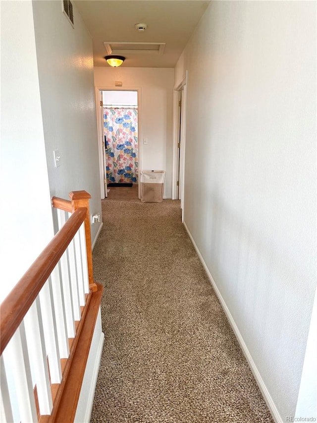 hallway featuring baseboards, visible vents, carpet flooring, and an upstairs landing