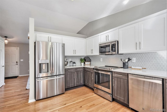 kitchen featuring decorative backsplash, light countertops, white cabinets, and stainless steel appliances