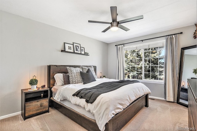 bedroom featuring baseboards, light colored carpet, and ceiling fan