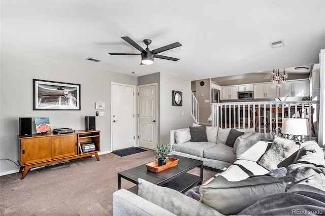 living area with stairs, baseboards, visible vents, and light carpet