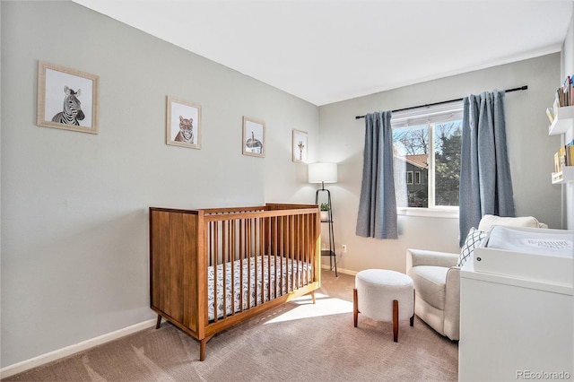 carpeted bedroom with a crib and baseboards