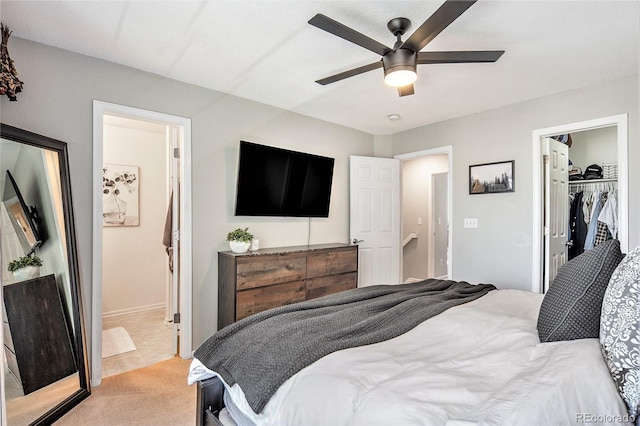 bedroom with light carpet, a ceiling fan, connected bathroom, a closet, and a spacious closet