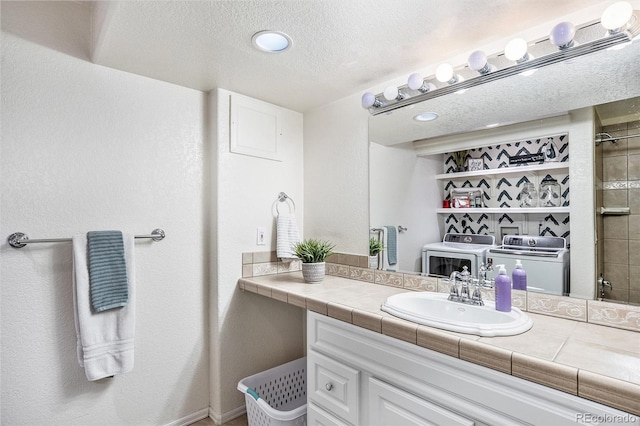 full bath featuring washer and dryer, a textured ceiling, and vanity