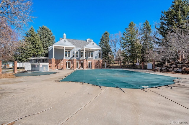 community pool with a patio and fence