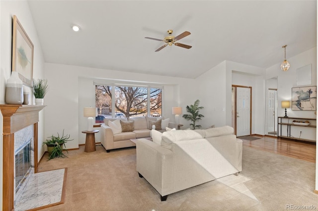 carpeted living room with ceiling fan and a high end fireplace