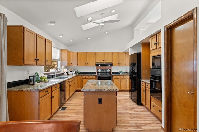 kitchen with a kitchen island, black appliances, sink, a skylight, and high vaulted ceiling