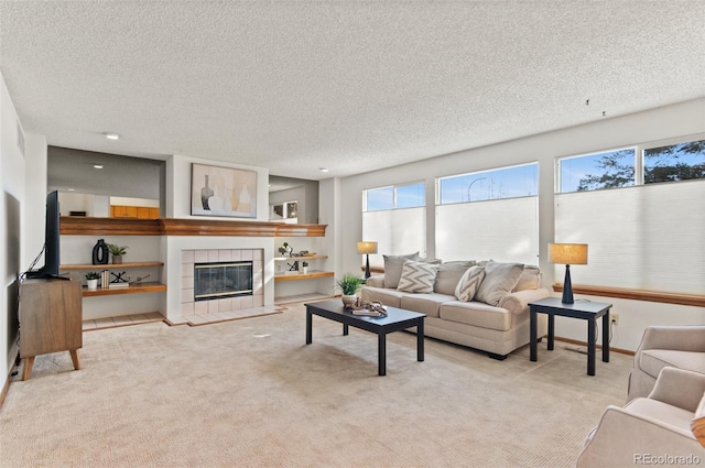 living room with a textured ceiling, light colored carpet, and a tiled fireplace