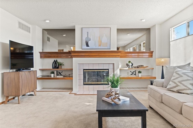 carpeted living room with a textured ceiling and a fireplace