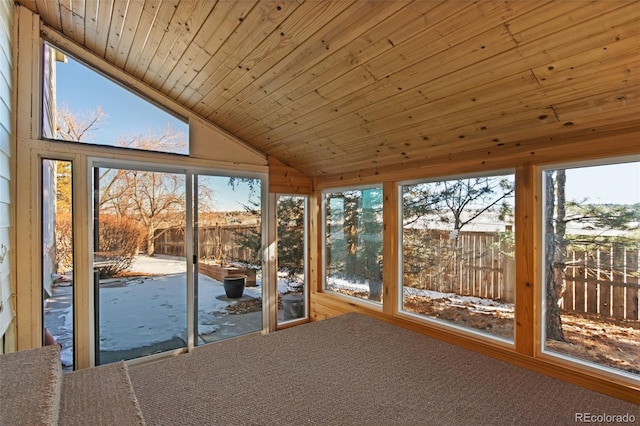 unfurnished sunroom with lofted ceiling, wood ceiling, and a healthy amount of sunlight