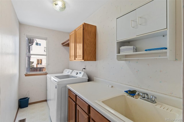 laundry room with independent washer and dryer, sink, and cabinets