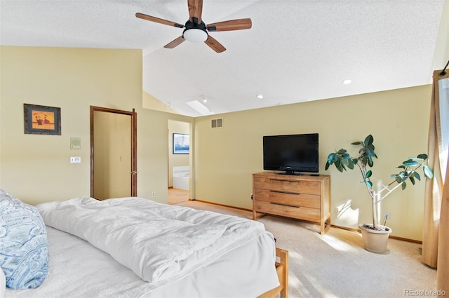 bedroom featuring light carpet, ceiling fan, ensuite bath, lofted ceiling, and a textured ceiling