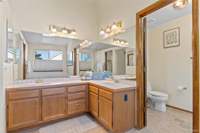 bathroom with toilet, vanity, and tile patterned flooring