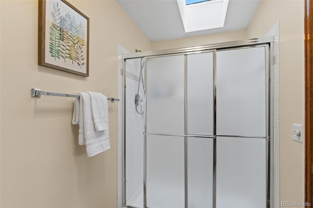 bathroom with a shower with door and a skylight