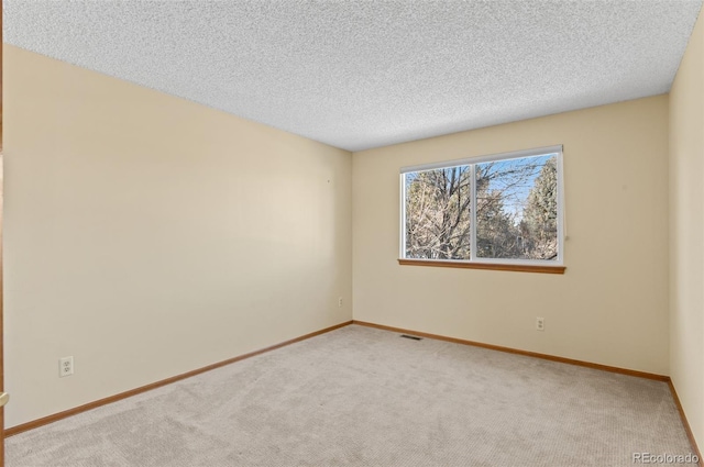 carpeted spare room featuring a textured ceiling