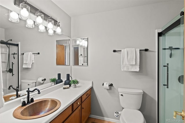 bathroom featuring a shower with shower door, vanity, and toilet