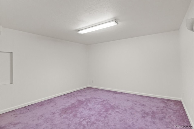 spare room with a textured ceiling and carpet flooring