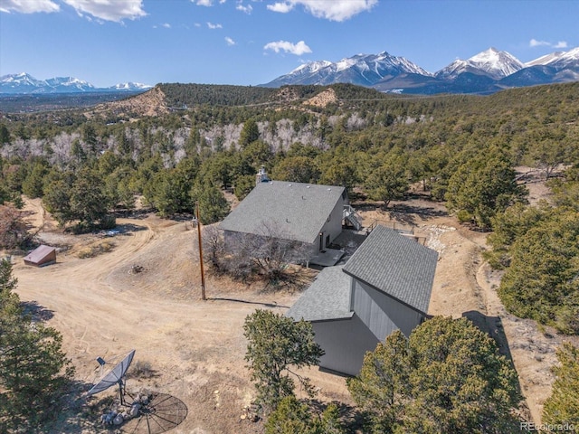 birds eye view of property featuring a forest view and a mountain view