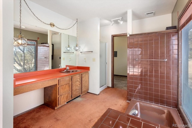 bathroom featuring a tub to relax in, baseboards, visible vents, walk in shower, and vanity