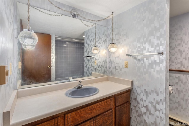 bathroom featuring wallpapered walls and vanity