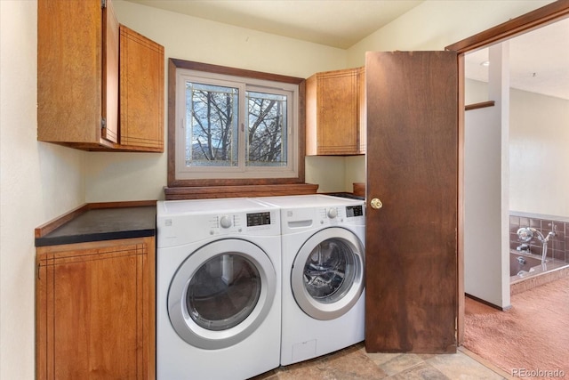 laundry area featuring light carpet, cabinet space, and washing machine and dryer