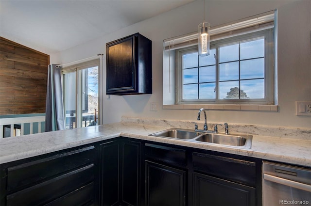 kitchen featuring stainless steel dishwasher, lofted ceiling, decorative light fixtures, and sink