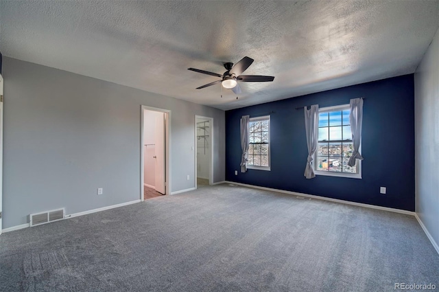 unfurnished bedroom featuring ceiling fan, light colored carpet, and a textured ceiling