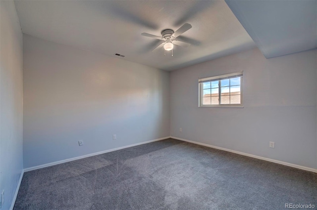 spare room featuring ceiling fan and dark carpet