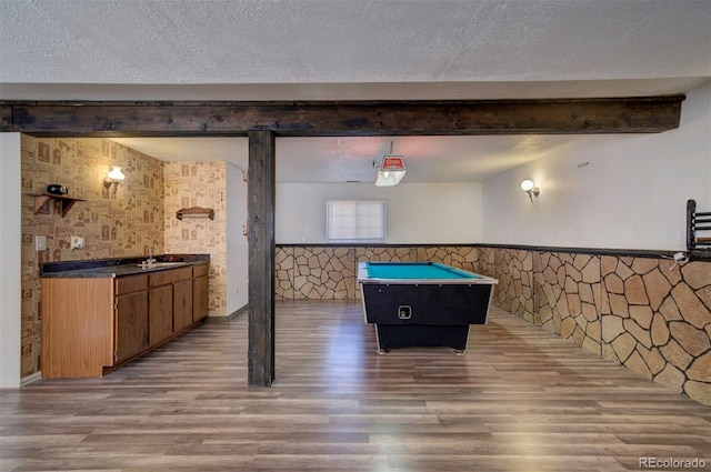 game room with sink, beamed ceiling, hardwood / wood-style floors, and a textured ceiling