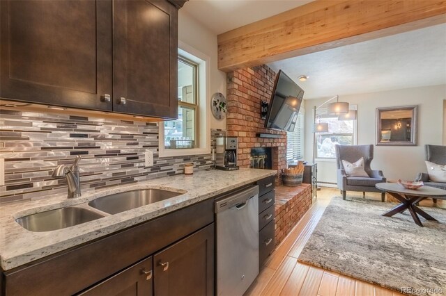 kitchen with stainless steel dishwasher, a sink, dark brown cabinets, decorative backsplash, and beamed ceiling