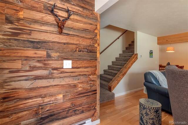 stairs featuring wood finished floors and baseboards