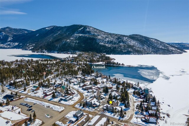snowy aerial view with a mountain view and a residential view
