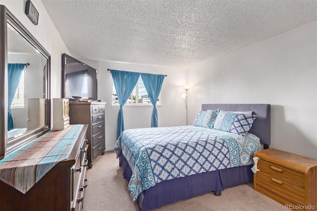 bedroom with light carpet and a textured ceiling