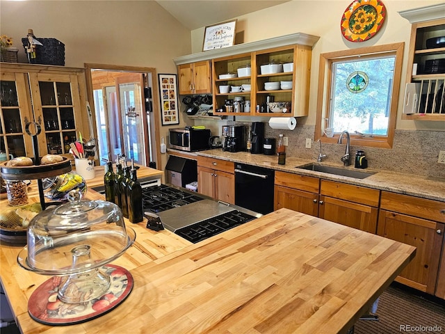 kitchen with vaulted ceiling, tasteful backsplash, black dishwasher, sink, and light stone countertops