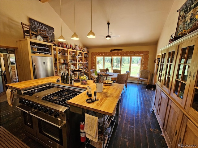 kitchen with stainless steel appliances, dark hardwood / wood-style floors, wooden counters, and high vaulted ceiling