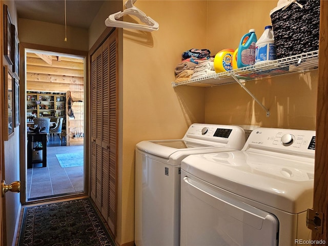 clothes washing area with washing machine and clothes dryer and rustic walls