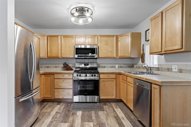 kitchen featuring tile countertops, hardwood / wood-style floors, sink, stainless steel appliances, and light brown cabinets